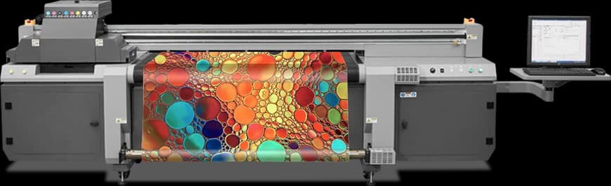 Impressora UV híbrida HandTop HT1600UV, vista frontal, com material impresso passando pelos cilindros e a estação de operação à direita